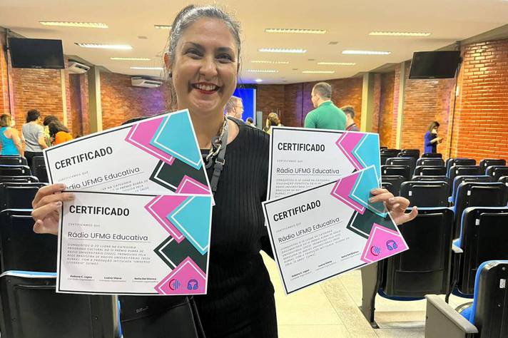 A diretora do Cedecom, Fábia Lima, com os certificados da Rádio UFMG Educativa no III Prêmio Rubra de Jornalismo Universitário