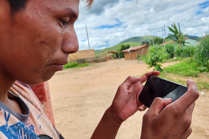 Indígena Maxakali usa internet no celular na aldeia Água Boa
