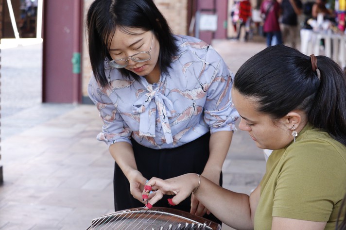 A professora Chen Ding ensinando o guzheng a Erika, que vai para a China no próximo semestre