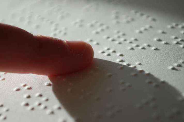Deficiente visual lê texto em braille: cotistas serão recebidos pelo NAI
