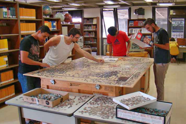 Usuários montam peças do quebra-cabeça na biblioteca do Departamento de Física