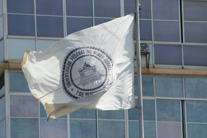 Bandeira da UFMG apressada em frente ao prédio da Reitoria, no campus Pampulha