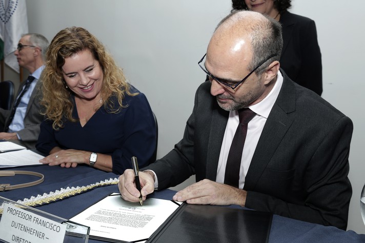Francisco Dutenhefner assina o termo de posse ao lado da reitora Sandra Regina Goulart Almeida