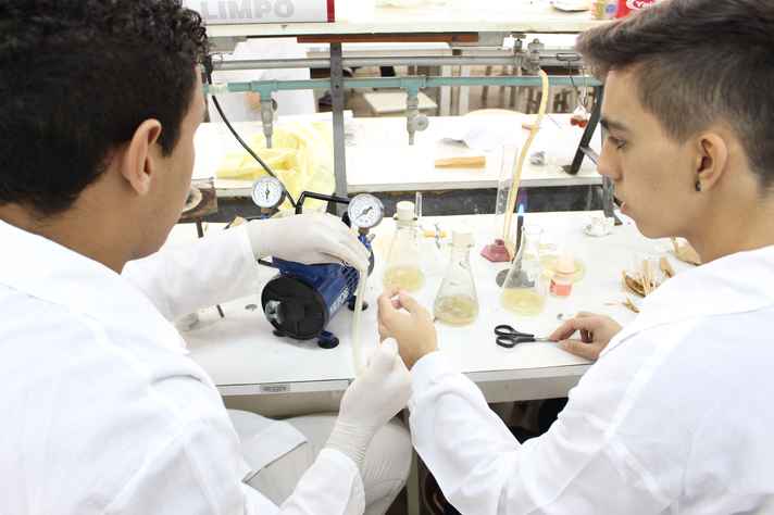 Gabriel (à direita) investiga o desenvolvimento de colônia de bactérias