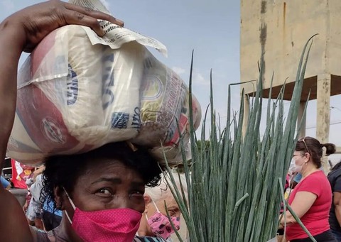 Mulher com cesta básica: raça e gênero são variáveis que pesam na questão da insegurança alimentar