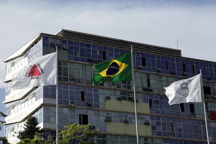 Bandeiras de Minas Gerais, do Brasil e da UFMG hasteadas em frente ao prédio da Reitoria