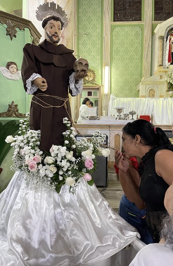 Devota beija o cordão do santo, na Igreja de São Caetano, em Cipotânea, Minas Gerais