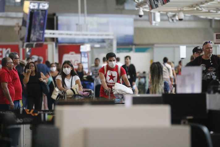 Passageiros e funcionários circulam vestindo máscaras contra o novo coronavírus (Covid-19) no Rio Galeão, Aeroporto Internacional Tom Jobim