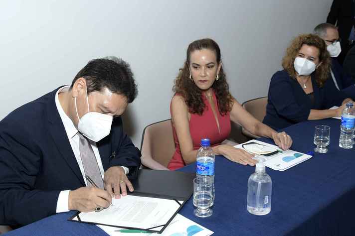 Observado pela professora Zélia Lobato e pela reitora Sandra Goulart Almeida, Afonso de Liguori assina o termo de posse