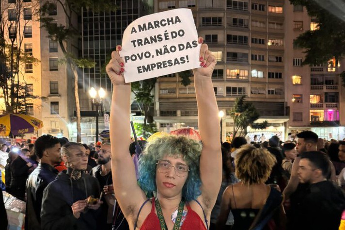 Cartaz da Marcha Trans realizada em São Paulo, em 2024, contrasta com tom da Parada principal.