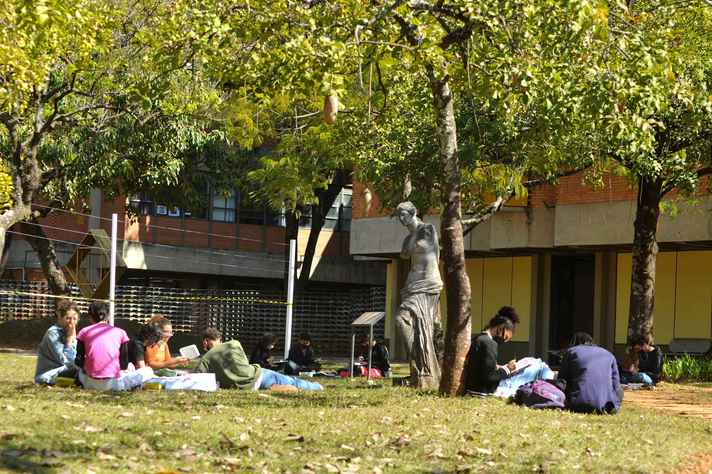 Estudantes em atividade no gramado da Escola de Belas-Artes: uso facultativo de máscara em espaços abertos