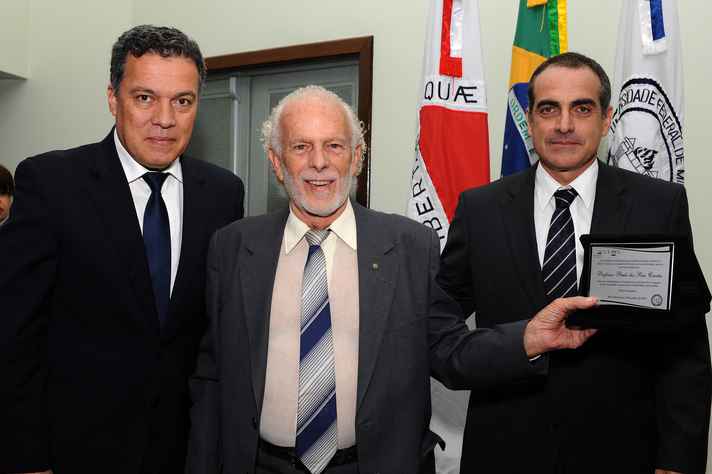 Um dos ex-diretores homenageados, professor Paulo dos Reis Corrêa recebe, do reitor Jaime Ramírez e do diretor Henrique Pretti, placa comemorativa