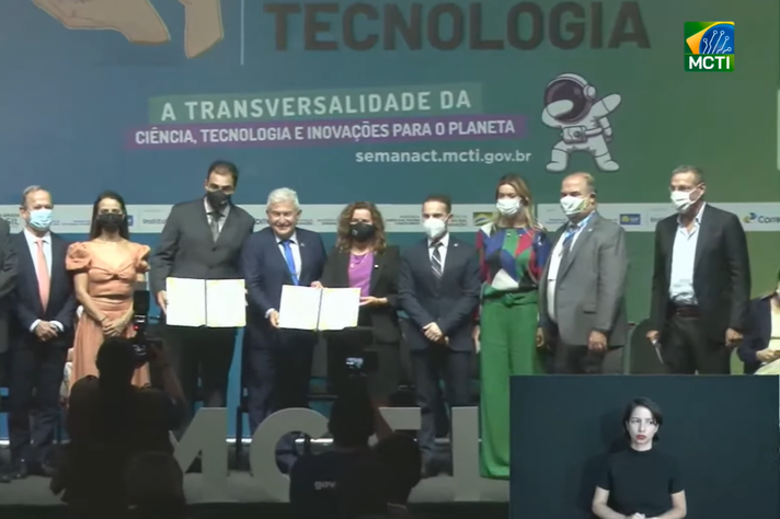 Ricardo Gazzinelli, Marcos Pontes e Sandra Goulart (ao centro) com cópias do acordo assinado