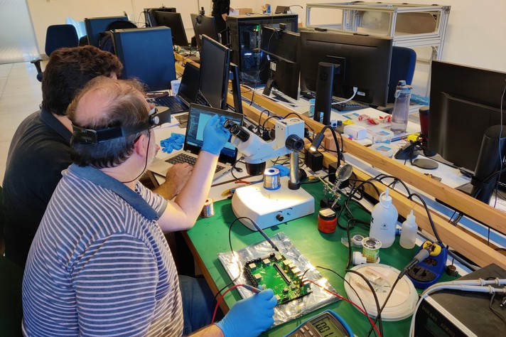 Profissionais da FabNS trabalham em testes de eletrônica e de sinais dentro da sede da empresa, no BH-TEC