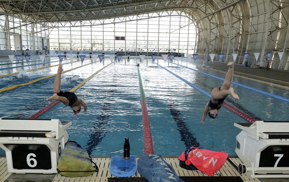 Crianças demonstram salto na piscina olímpica durante visita de secretária ao CTE