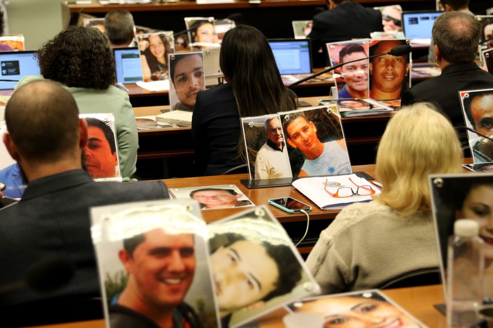 Familiares com fotos das vitimas da tragédia durante discussão e votação do relatório final da CPI de Brumadinho