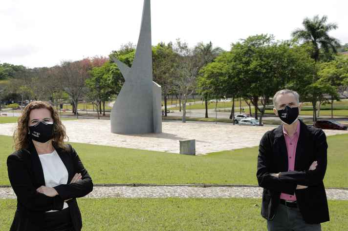 Sandra Goulart e Alessandro com o Monumento ao Aleijadinho, no campus Pampulha, ao fundo: