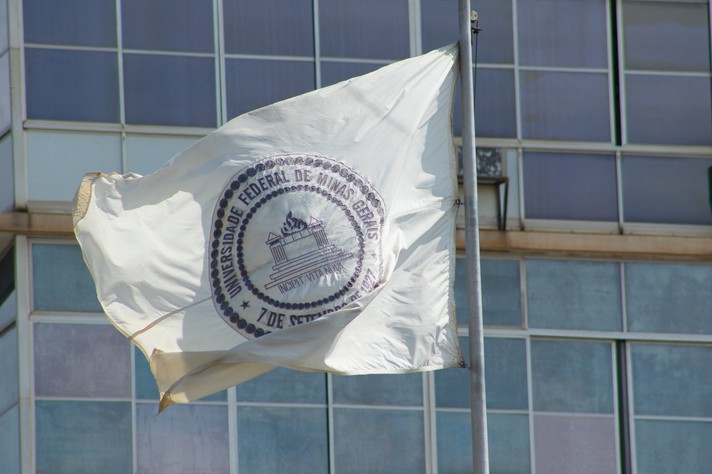Bandeira da UFMG em frente ao prédio da Reitoria, no campus Pampulha